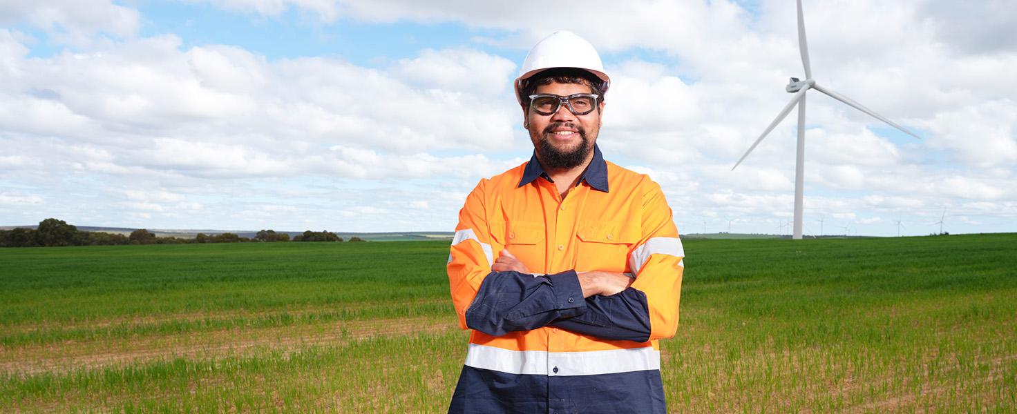 male with protective gear with wind turbine setting
